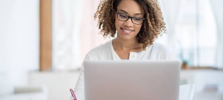 A woman smiling infront of her machine